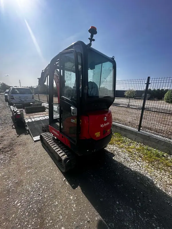 Minikoparka Kubota KX019-4 załadowana na przyczepie transportowej, gotowa do wyjazdu na zlecenie.